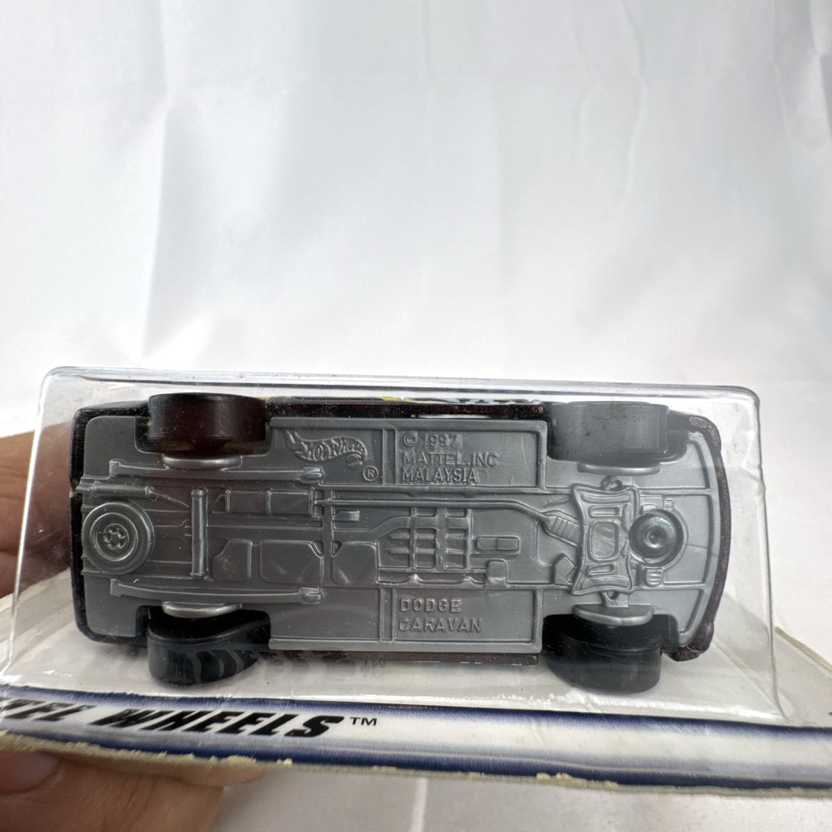 Sealed 1998 Hot Wheels First Editions Dodge Caravan diecast minivan in metallic purple on original card packaging.