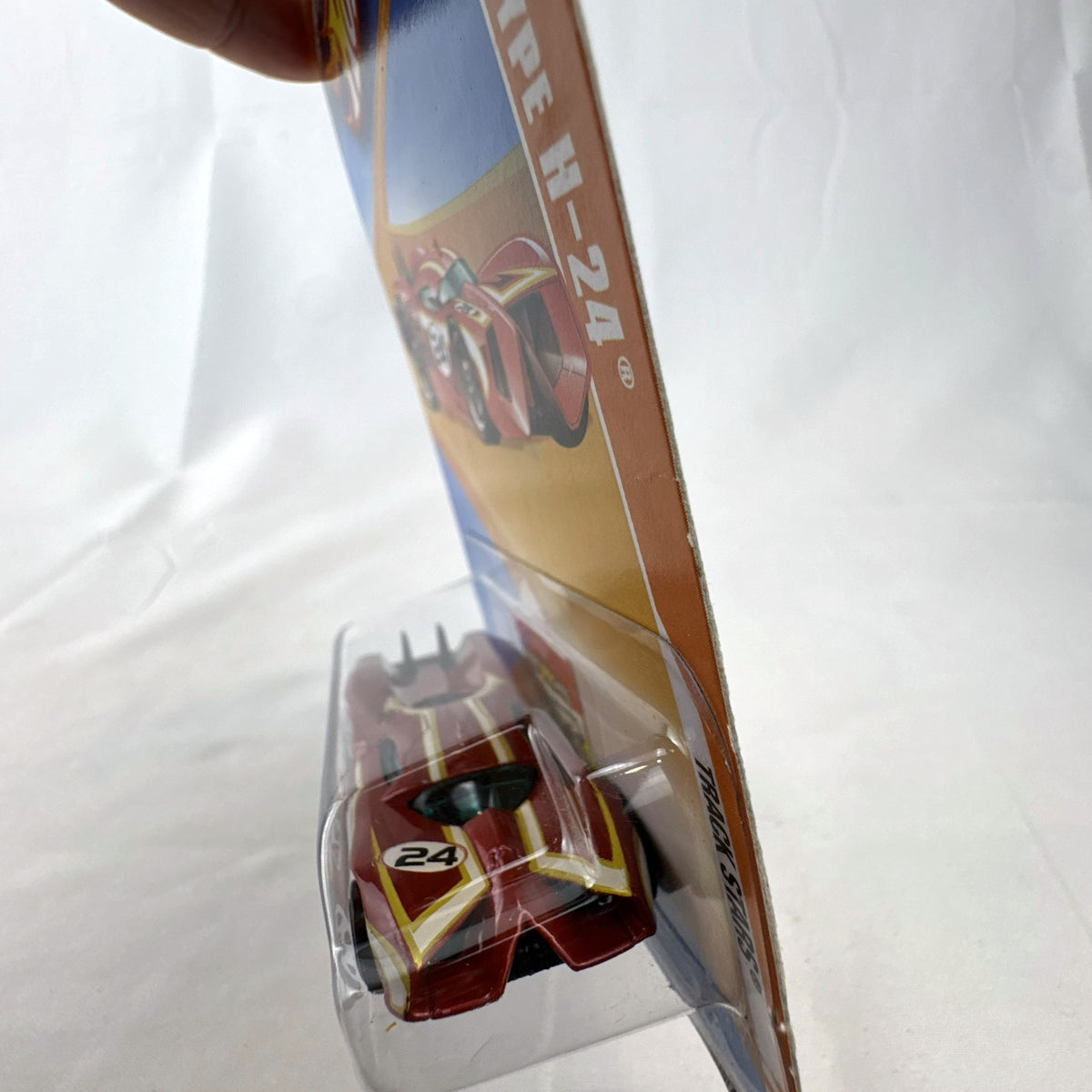 Sealed 2010 Hot Wheels Track Stars Prototype H-24 diecast car in dark metallic red on original blister card.