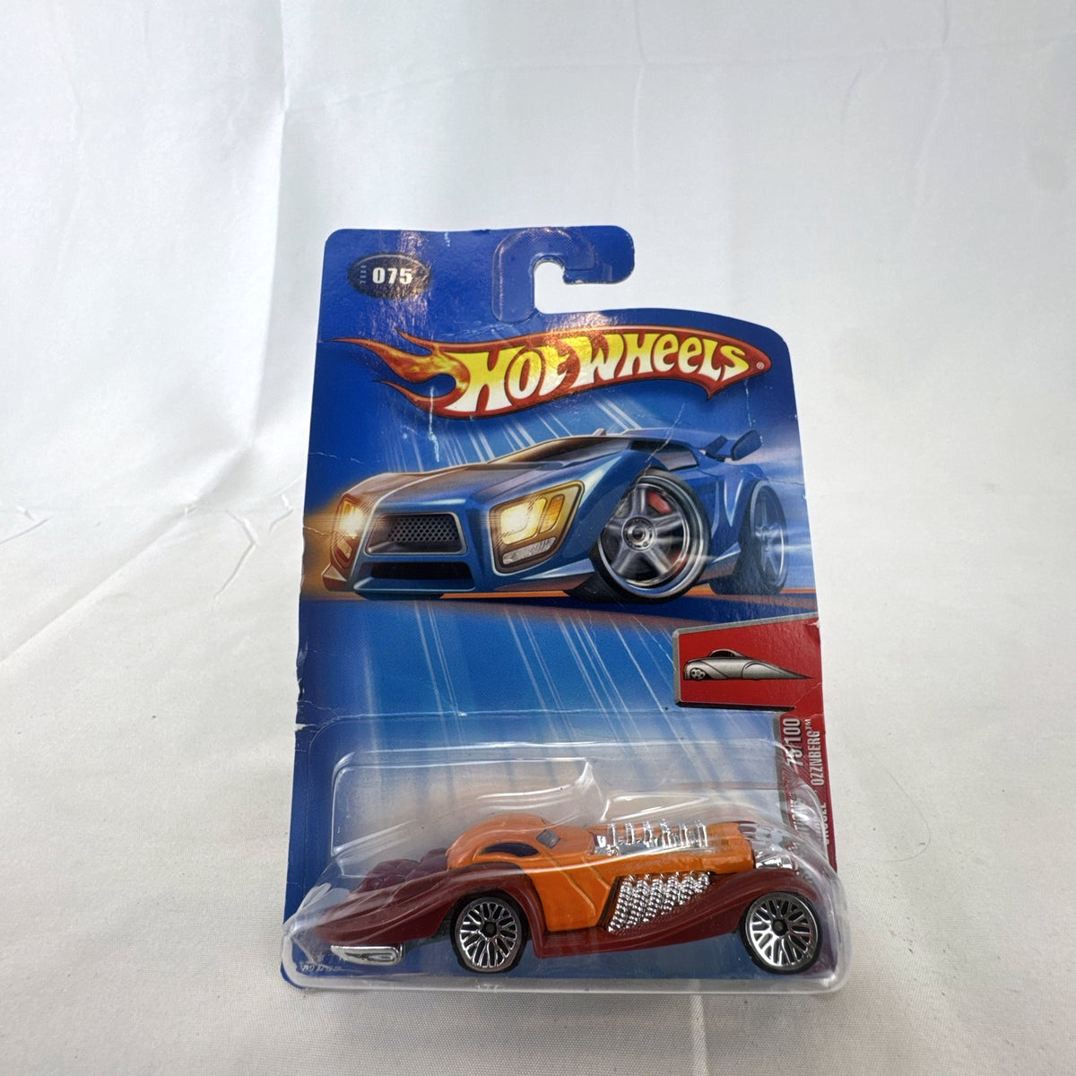 Sealed 2004 Hot Wheels First Editions Ozzenberg 1:64 diecast car in orange and maroon packaging.