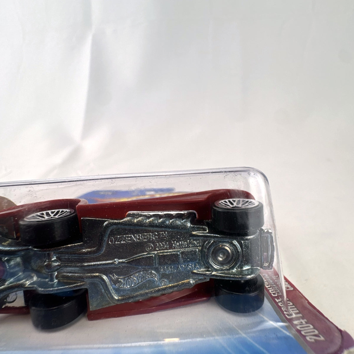 Sealed 2004 Hot Wheels First Editions Ozzenberg 1:64 diecast car in orange and maroon packaging.