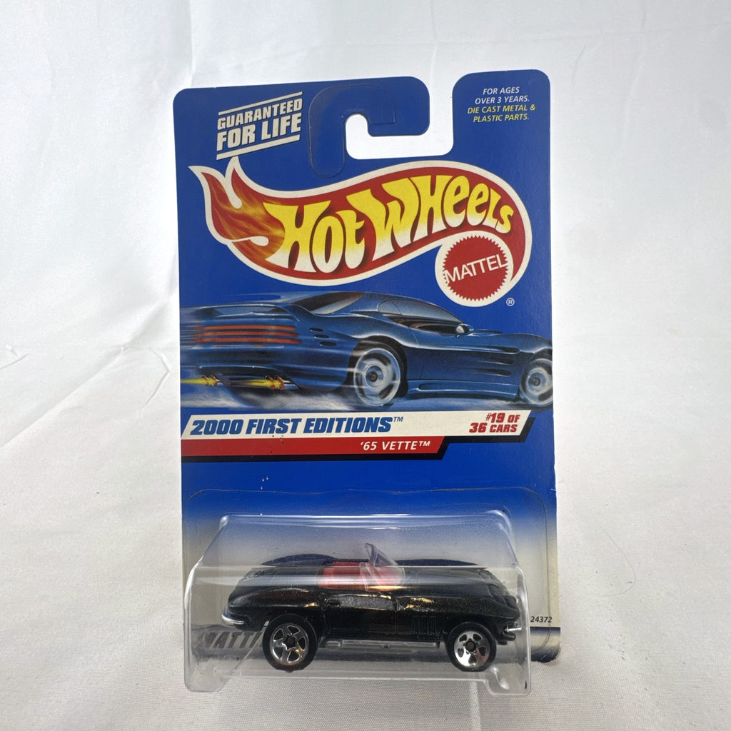 Hot Wheels 2000 First Editions 1965 Chevrolet Corvette diecast car in metallic black with red interior, unopened on card.