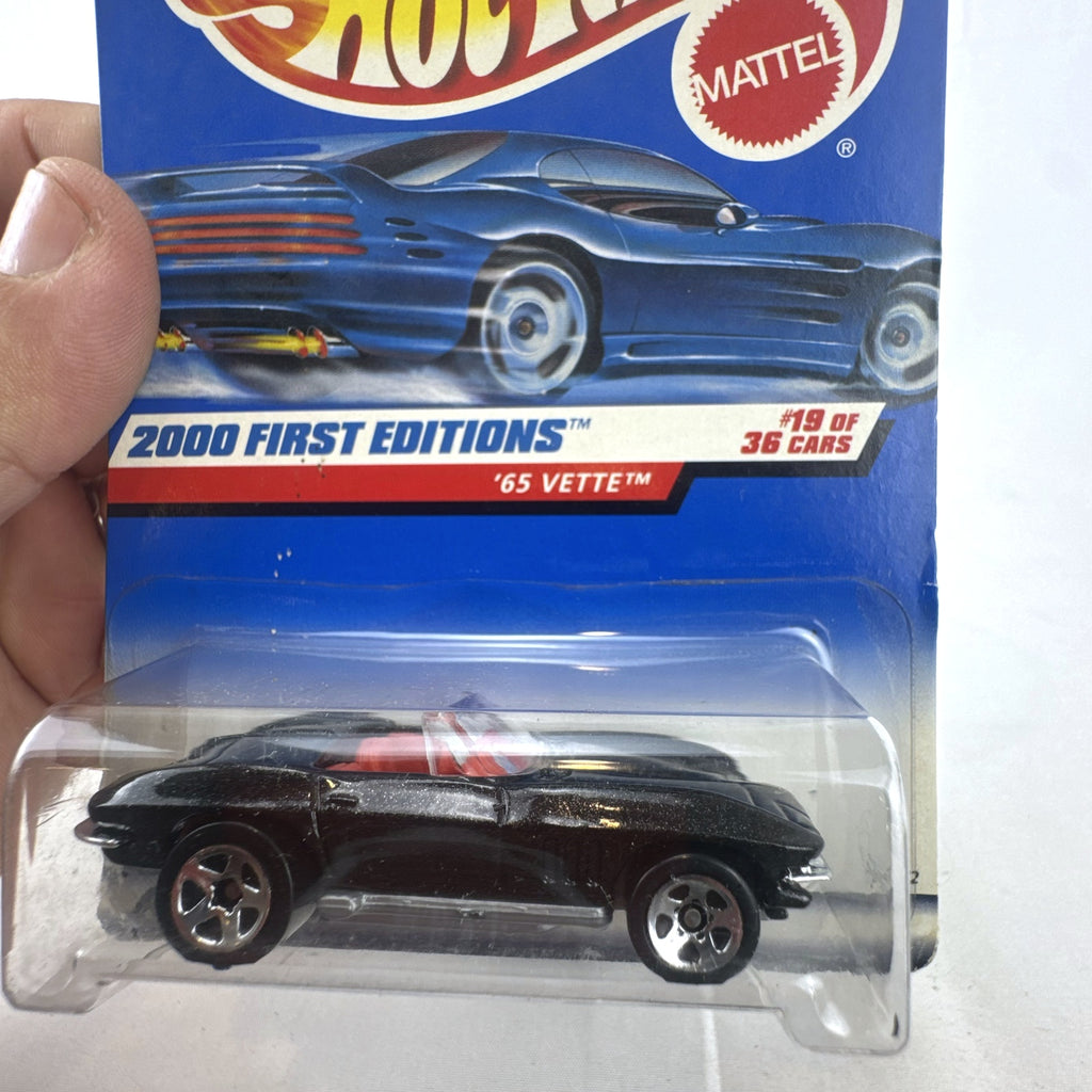 Hot Wheels 2000 First Editions 1965 Chevrolet Corvette diecast car in metallic black with red interior, unopened on card.