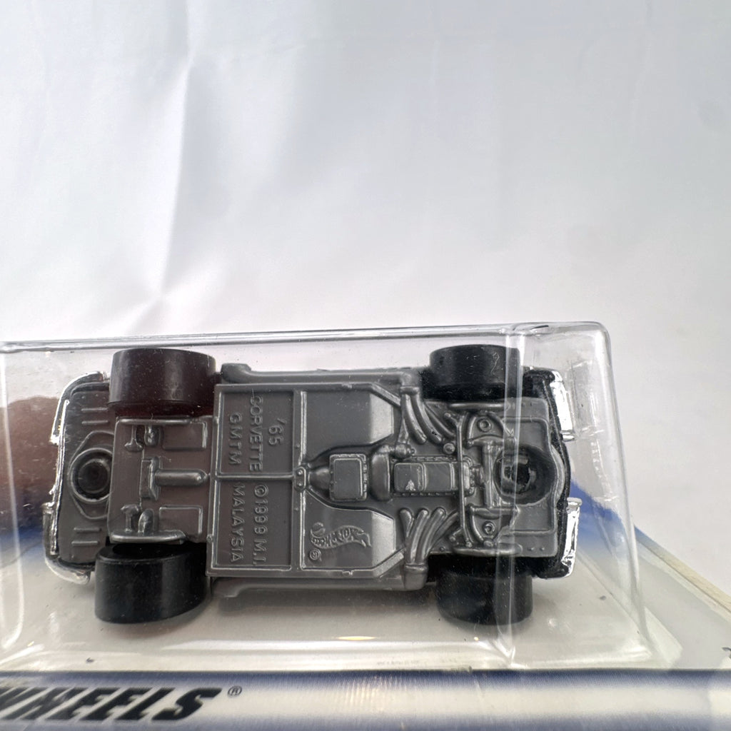 Hot Wheels 2000 First Editions 1965 Chevrolet Corvette diecast car in metallic black with red interior, unopened on card.