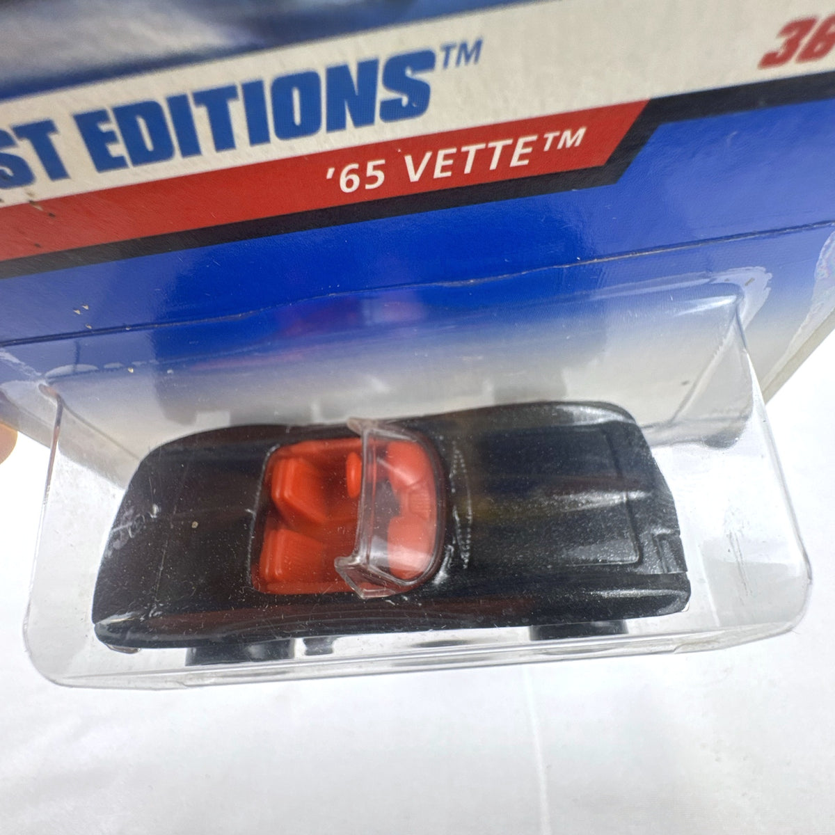 Hot Wheels 2000 First Editions 1965 Chevrolet Corvette diecast car in metallic black with red interior, unopened on card.