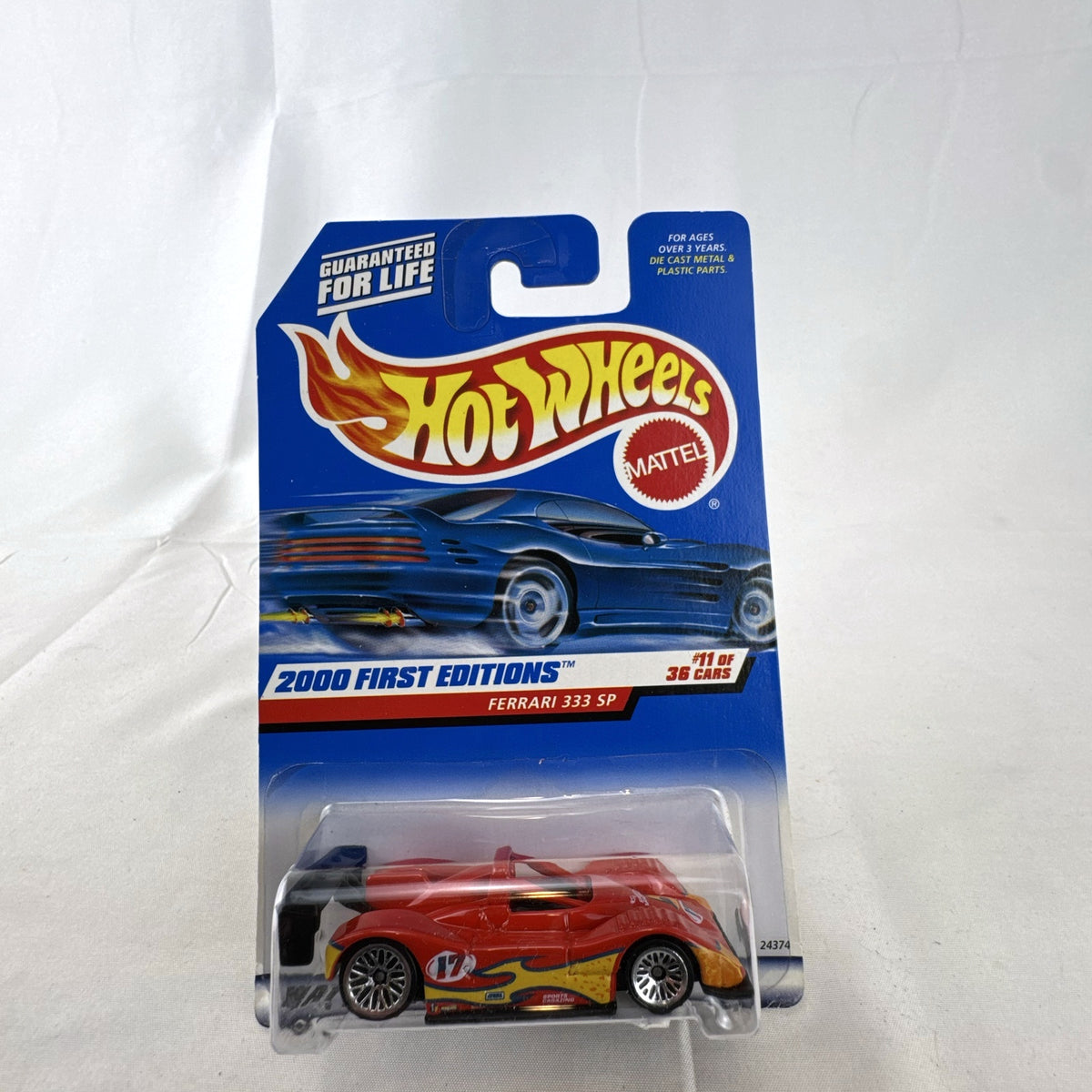 Hot Wheels 2000 First Editions Ferrari 333 SP 1:64 diecast race car in red with yellow flame graphics, sealed on card.