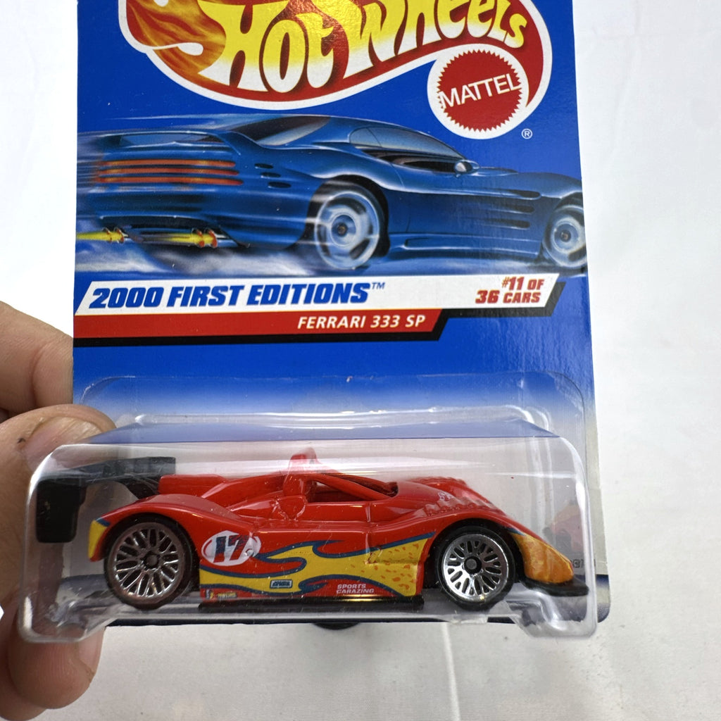 Hot Wheels 2000 First Editions Ferrari 333 SP 1:64 diecast race car in red with yellow flame graphics, sealed on card.