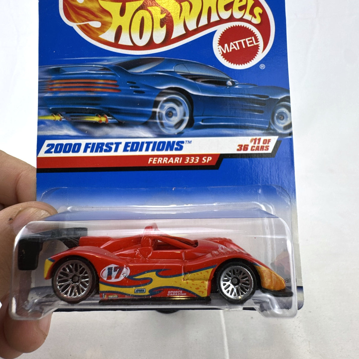 Hot Wheels 2000 First Editions Ferrari 333 SP 1:64 diecast race car in red with yellow flame graphics, sealed on card.