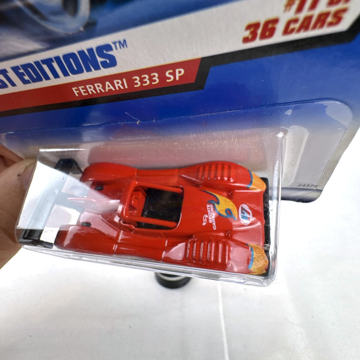 Hot Wheels 2000 First Editions Ferrari 333 SP 1:64 diecast race car in red with yellow flame graphics, sealed on card.