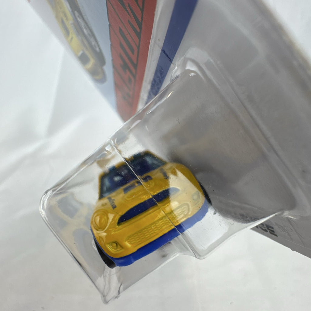 Factory sealed Hot Wheels 1:64 MINI Cooper S Challenge Flying Customs diecast car in yellow with blue racing stripes.