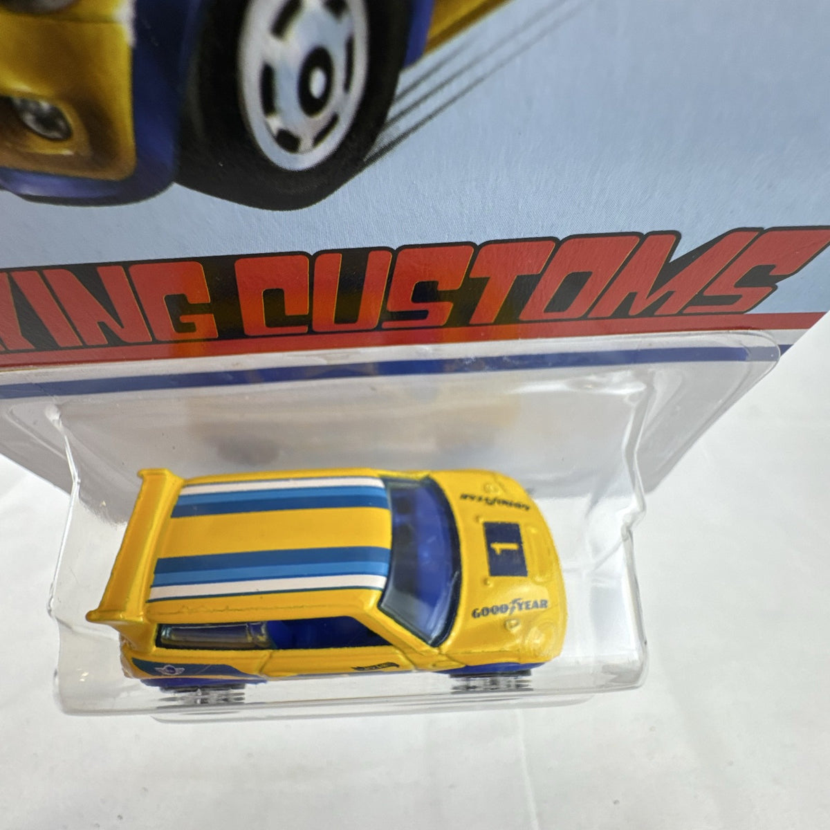 Factory sealed Hot Wheels 1:64 MINI Cooper S Challenge Flying Customs diecast car in yellow with blue racing stripes.