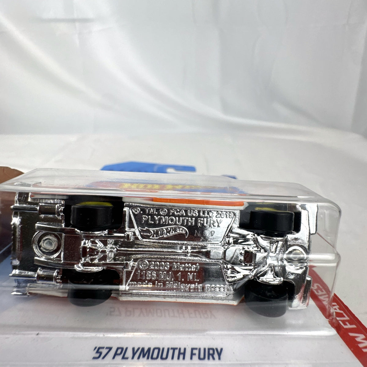 Hot Wheels 1:64 scale '57 Plymouth Fury diecast car in white with HW Flames graphics in original sealed packaging.