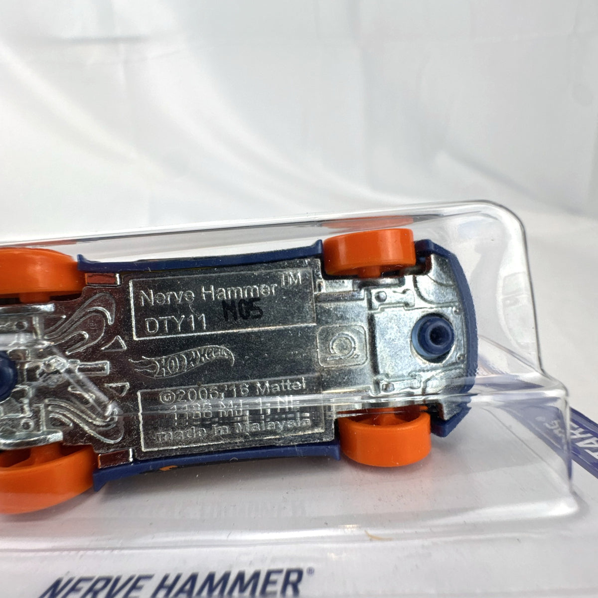 Hot Wheels 1:64 scale Nerve Hammer diecast car in deep blue with orange wheels, sealed on original card.