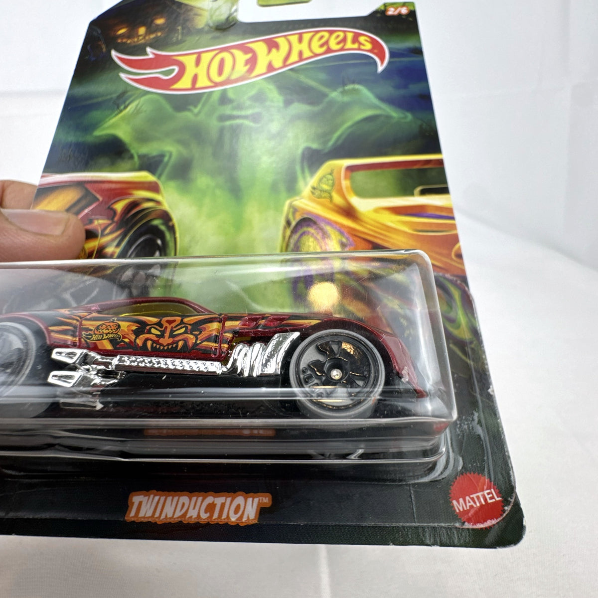 Hot Wheels 1:64 scale Twinduction Halloween Series metallic red diecast muscle car in original sealed packaging.