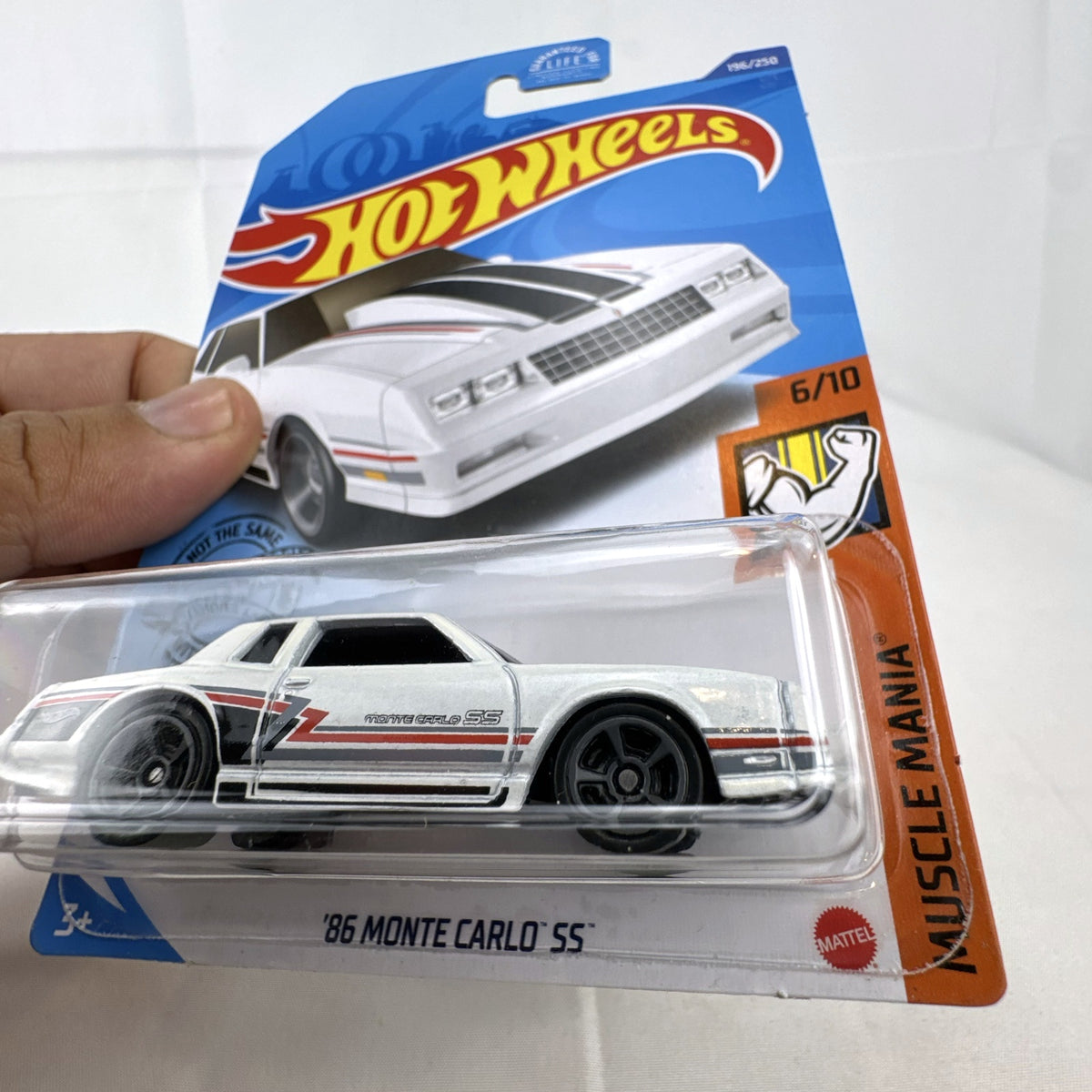 Hot Wheels 1:64 scale 1986 Chevrolet Monte Carlo SS diecast car in white with retro stripes in factory sealed packaging