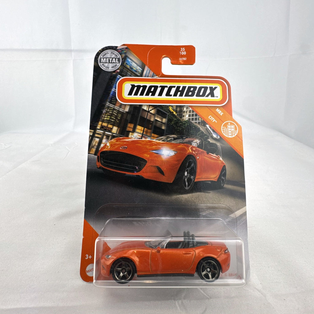 Factory-sealed Matchbox 1:64 scale 2015 Mazda MX-5 Miata diecast model car in metallic orange on original blister card