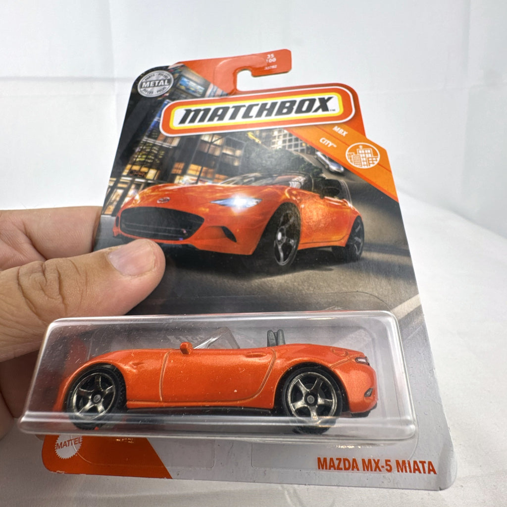 Factory-sealed Matchbox 1:64 scale 2015 Mazda MX-5 Miata diecast model car in metallic orange on original blister card