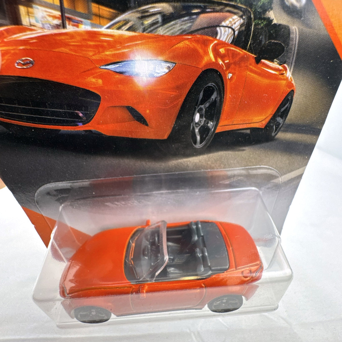 Factory-sealed Matchbox 1:64 scale 2015 Mazda MX-5 Miata diecast model car in metallic orange on original blister card