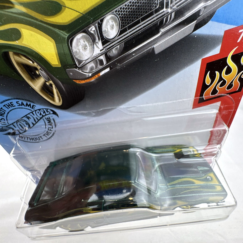 Hot Wheels 1:64 scale 1973 Ford Falcon XB diecast car in dark green with yellow and green HW Flames livery.
