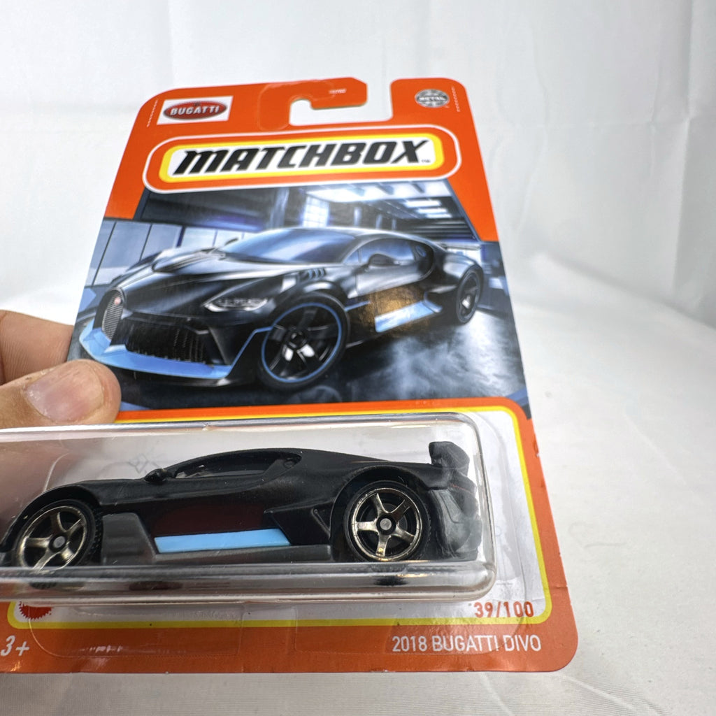 Matchbox 1:64 scale Bugatti Divo diecast car in matte black with blue accents on original card packaging