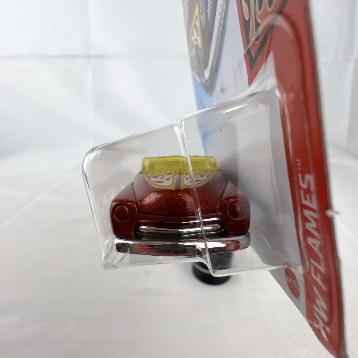 Hot Wheels 1:64 scale '49 Merc diecast convertible in metallic red with yellow and white flame graphics, sealed on card.