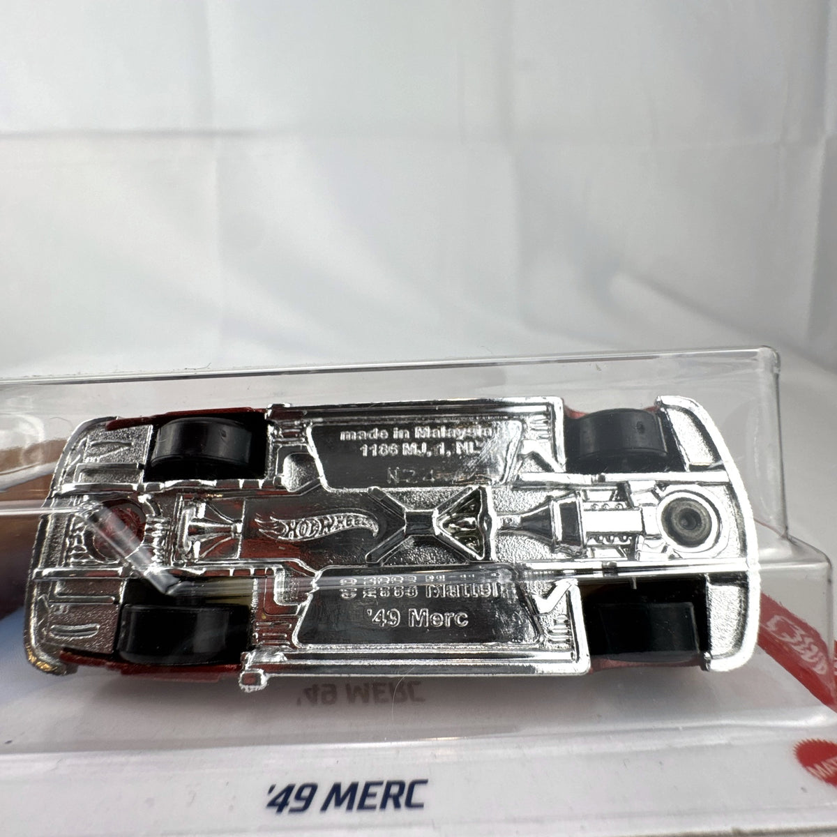 Hot Wheels 1:64 scale '49 Merc diecast convertible in metallic red with yellow and white flame graphics, sealed on card.