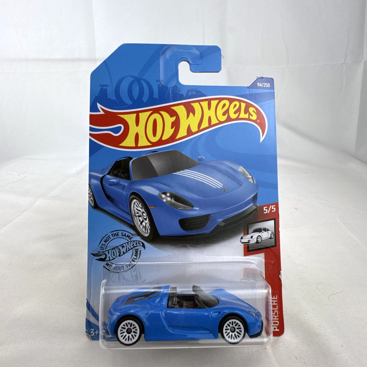 Sealed 1:64 scale Hot Wheels Porsche 918 Spyder diecast car in blue with white racing stripes in original packaging