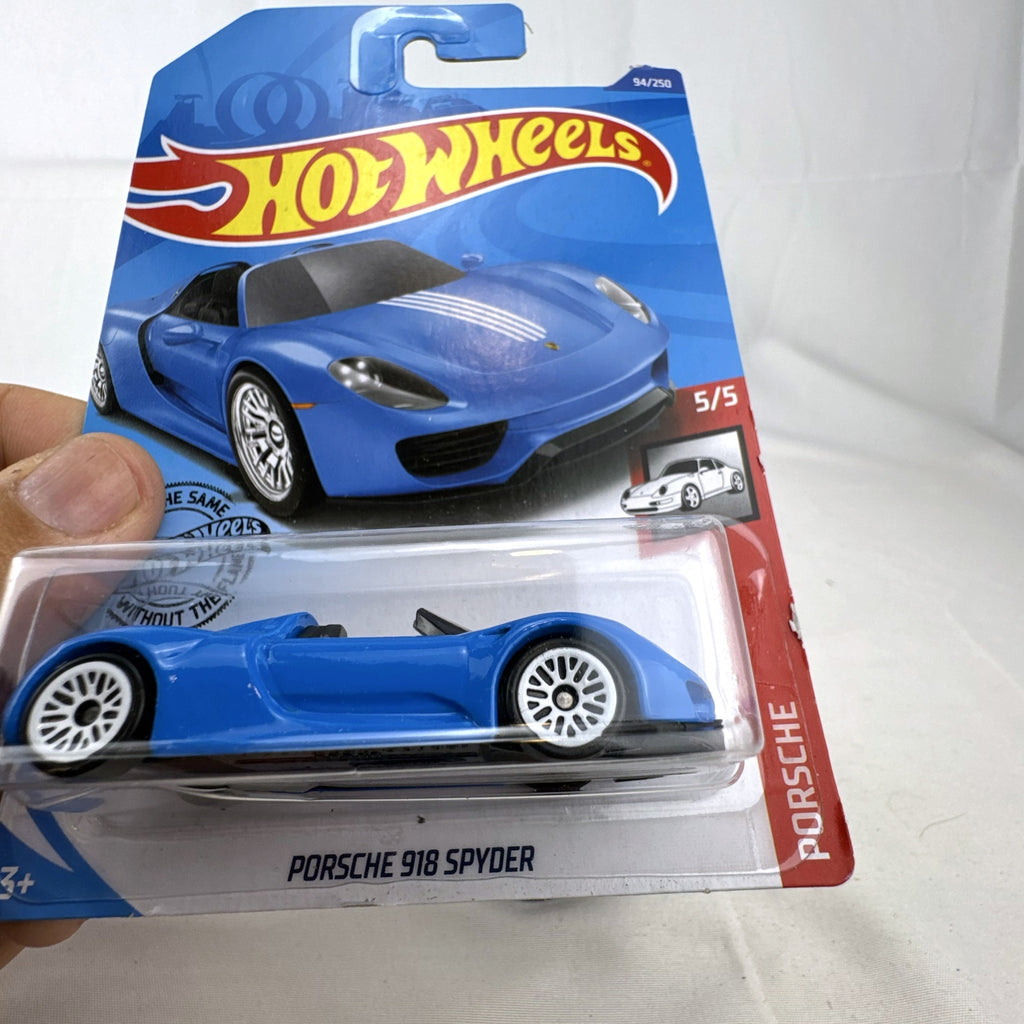 Sealed 1:64 scale Hot Wheels Porsche 918 Spyder diecast car in blue with white racing stripes in original packaging