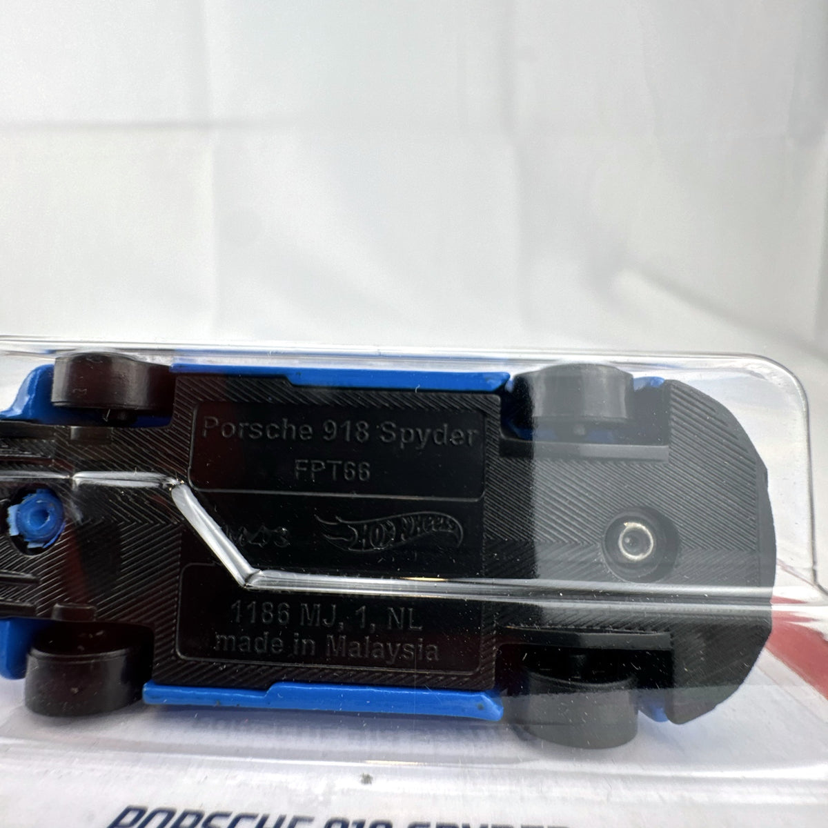 Sealed 1:64 scale Hot Wheels Porsche 918 Spyder diecast car in blue with white racing stripes in original packaging