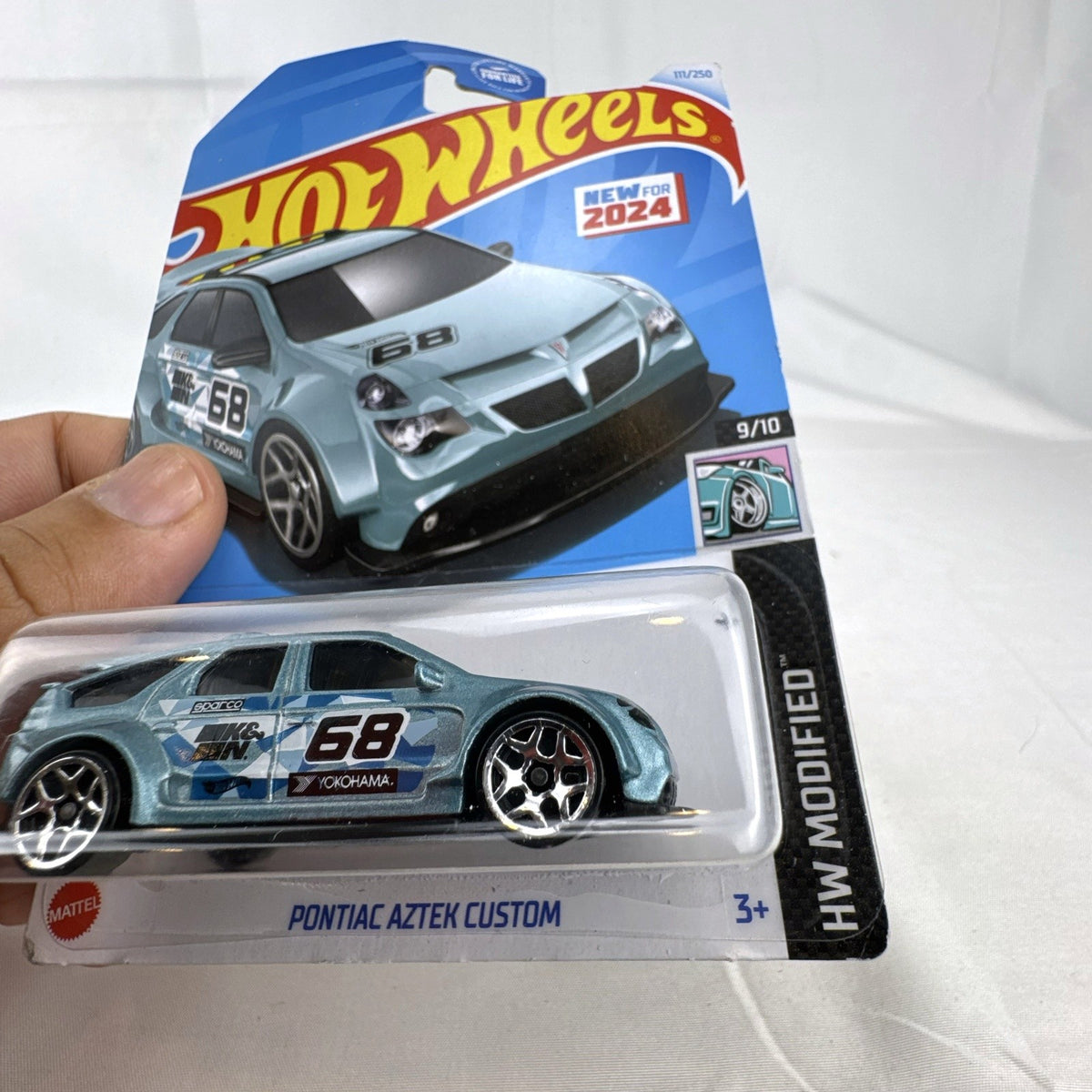 Hot Wheels 1:64 scale Pontiac Aztek Custom diecast car in metallic light blue, sealed on original HW Modified card.