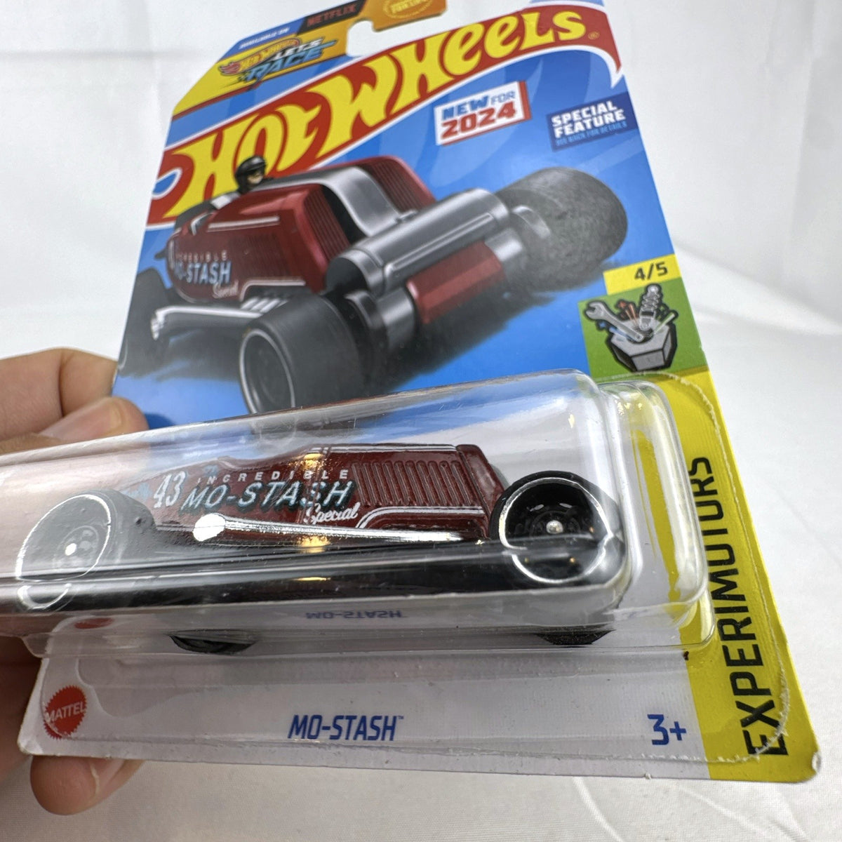 Hot Wheels Mo-Stash 1:64 diecast car in dark red with white graphics sealed on card from the 2024 Experimotors series