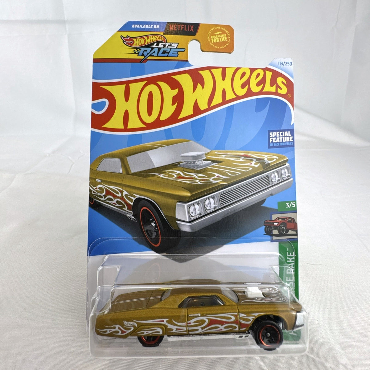 Hot Wheels 1:64 scale Layin' Lowrider diecast car in gold with red and white flame tampos in original carded packaging