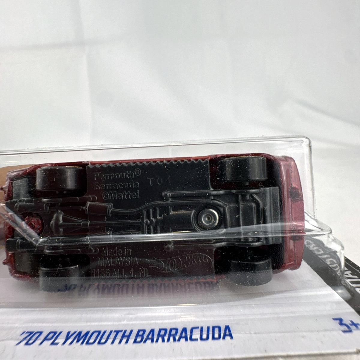 Hot Wheels 1:64 scale 1970 Plymouth Barracuda convertible diecast car in metallic red with gold wheels in sealed package.