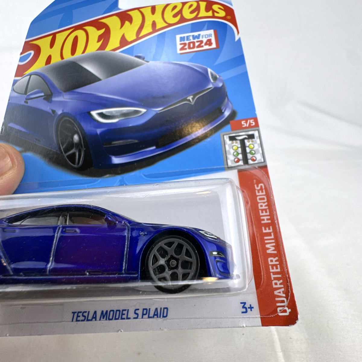 Factory sealed Hot Wheels 1:64 scale Tesla Model S Plaid diecast car in metallic blue on original 2024 card.