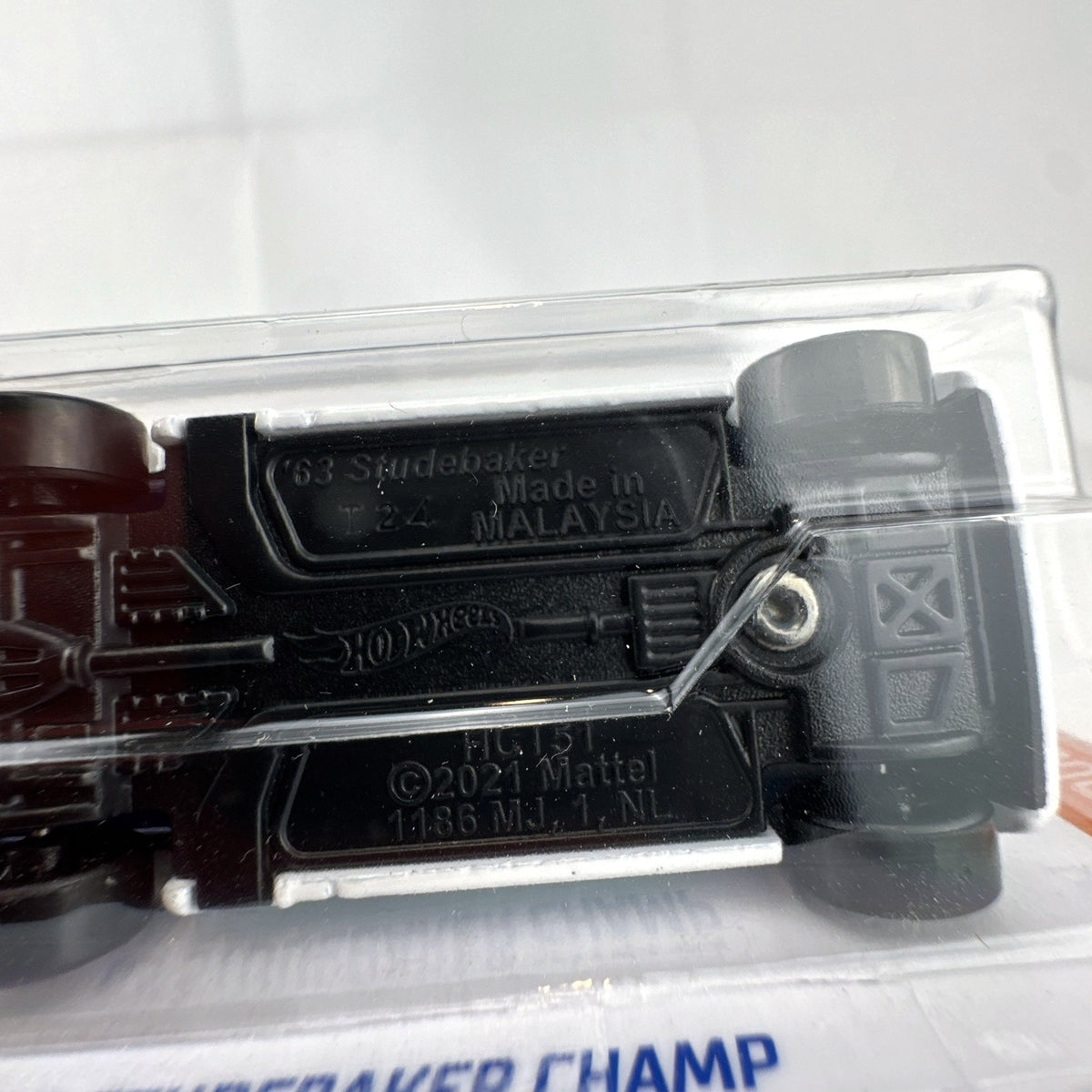 Hot Wheels 1:64 scale 1963 Studebaker Champ pickup truck in white with teal side graphics, sealed in original package.