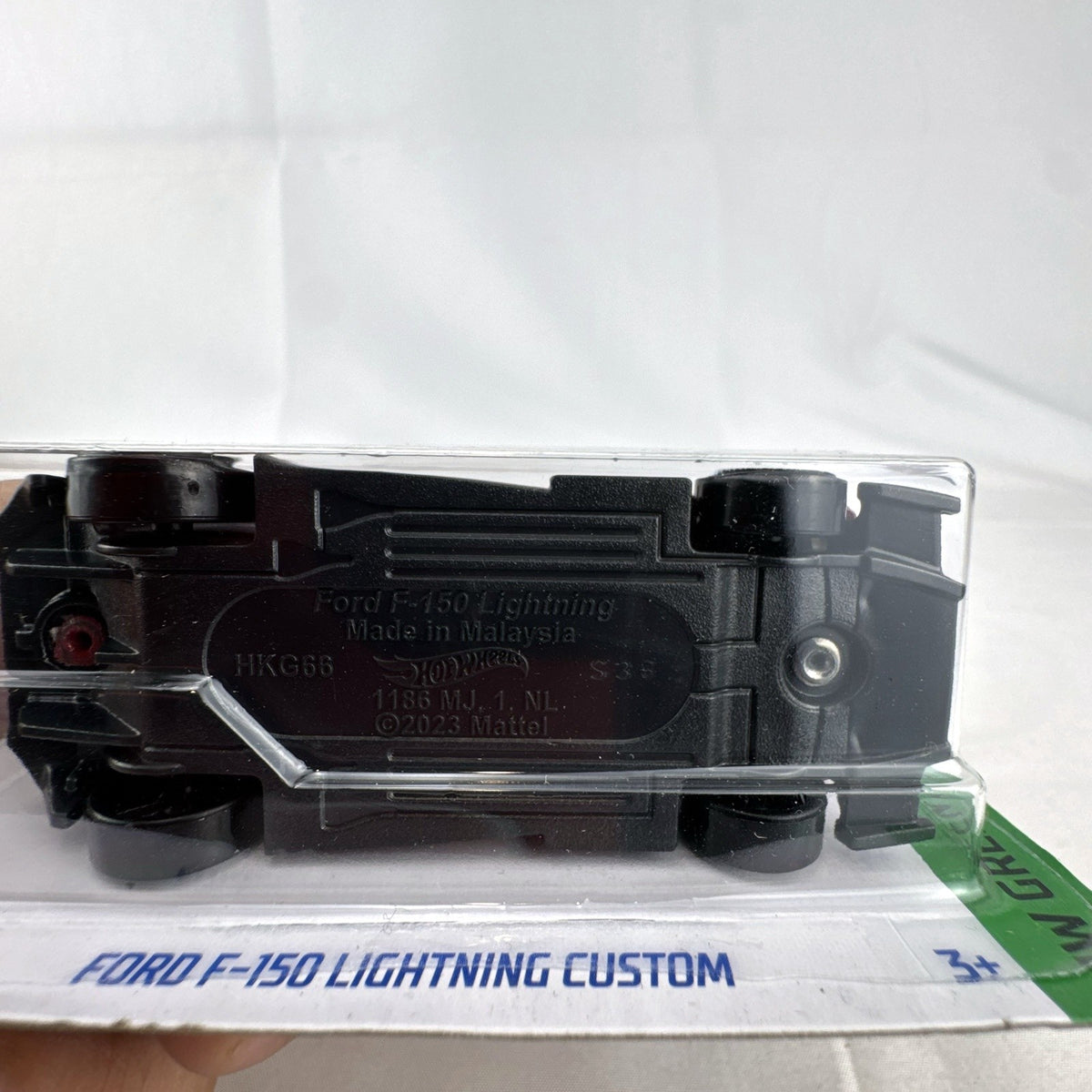 Hot Wheels 1:64 scale Ford F-150 Lightning Custom diecast truck in dark red on unopened original card packaging.