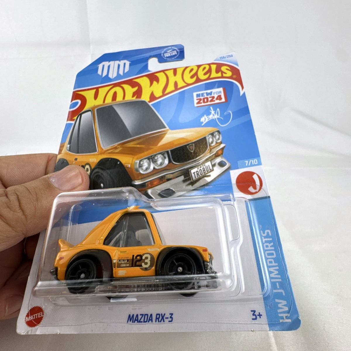 Hot Wheels 1:64 scale Tooned Mazda RX-3 diecast car in bright orange, factory sealed on original card.