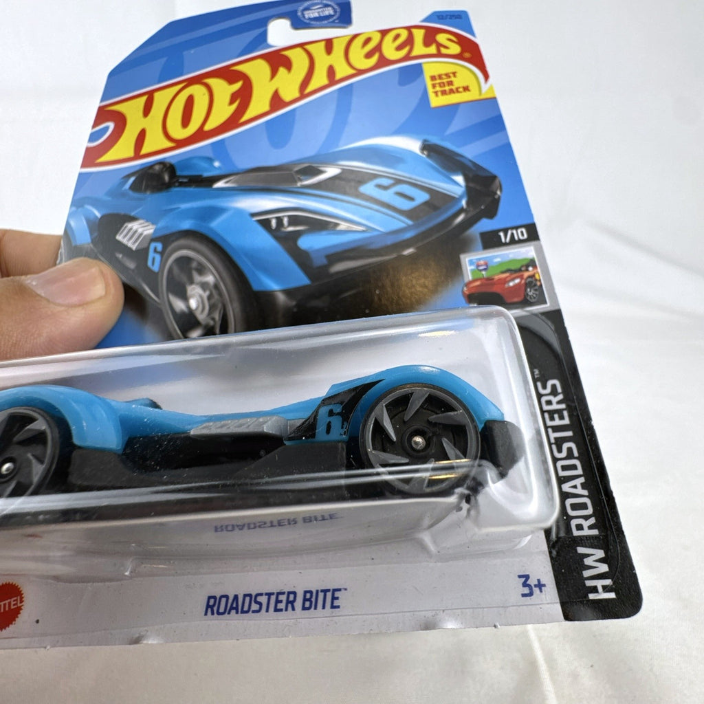 Hot Wheels Roadster Bite 1:64 scale diecast car in blue with black racing stripes in original unopened packaging.