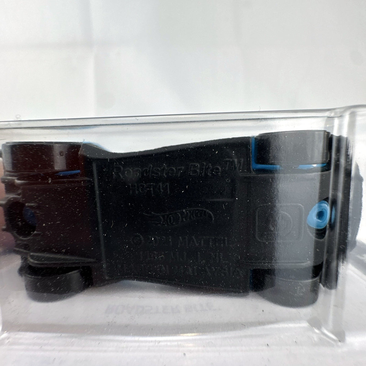 Hot Wheels Roadster Bite 1:64 scale diecast car in blue with black racing stripes in original unopened packaging.