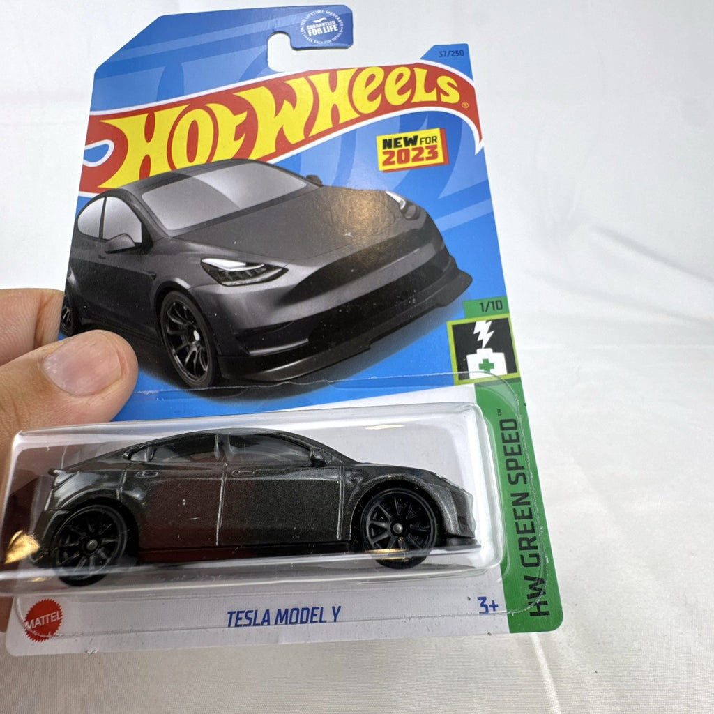 Hot Wheels 1:64 scale diecast Tesla Model Y SUV in dark gray metallic inside factory sealed card packaging.