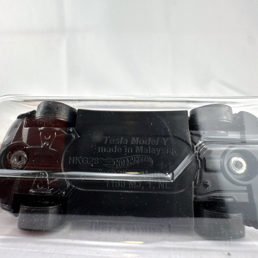Hot Wheels 1:64 scale diecast Tesla Model Y SUV in dark gray metallic inside factory sealed card packaging.