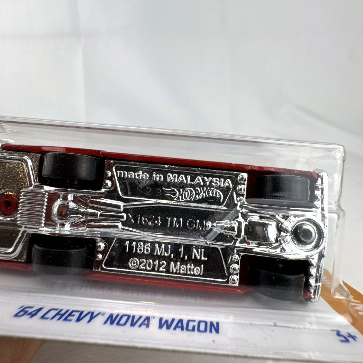 Hot Wheels 1964 Chevy Nova Wagon 1:64 scale diecast car in deep red with white roof sealed on blister card.