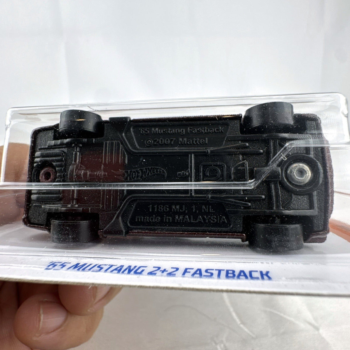 Hot Wheels 1:64 scale 1965 Ford Mustang 2+2 Fastback diecast car in dark maroon with white racing stripes factory sealed.