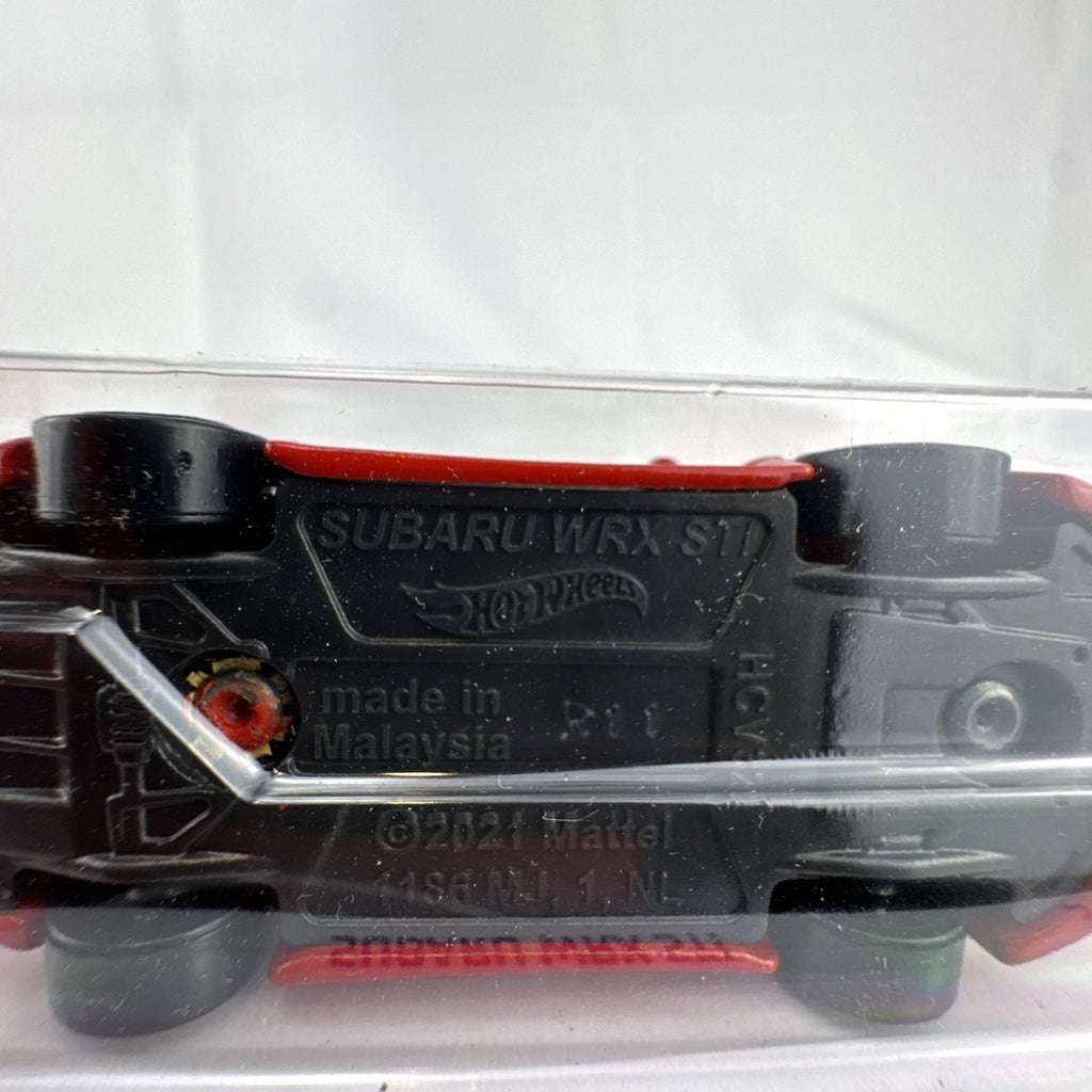 Hot Wheels 1:64 scale Subaru WRX STI diecast car in red sealed on HW Hatchbacks card packaging.