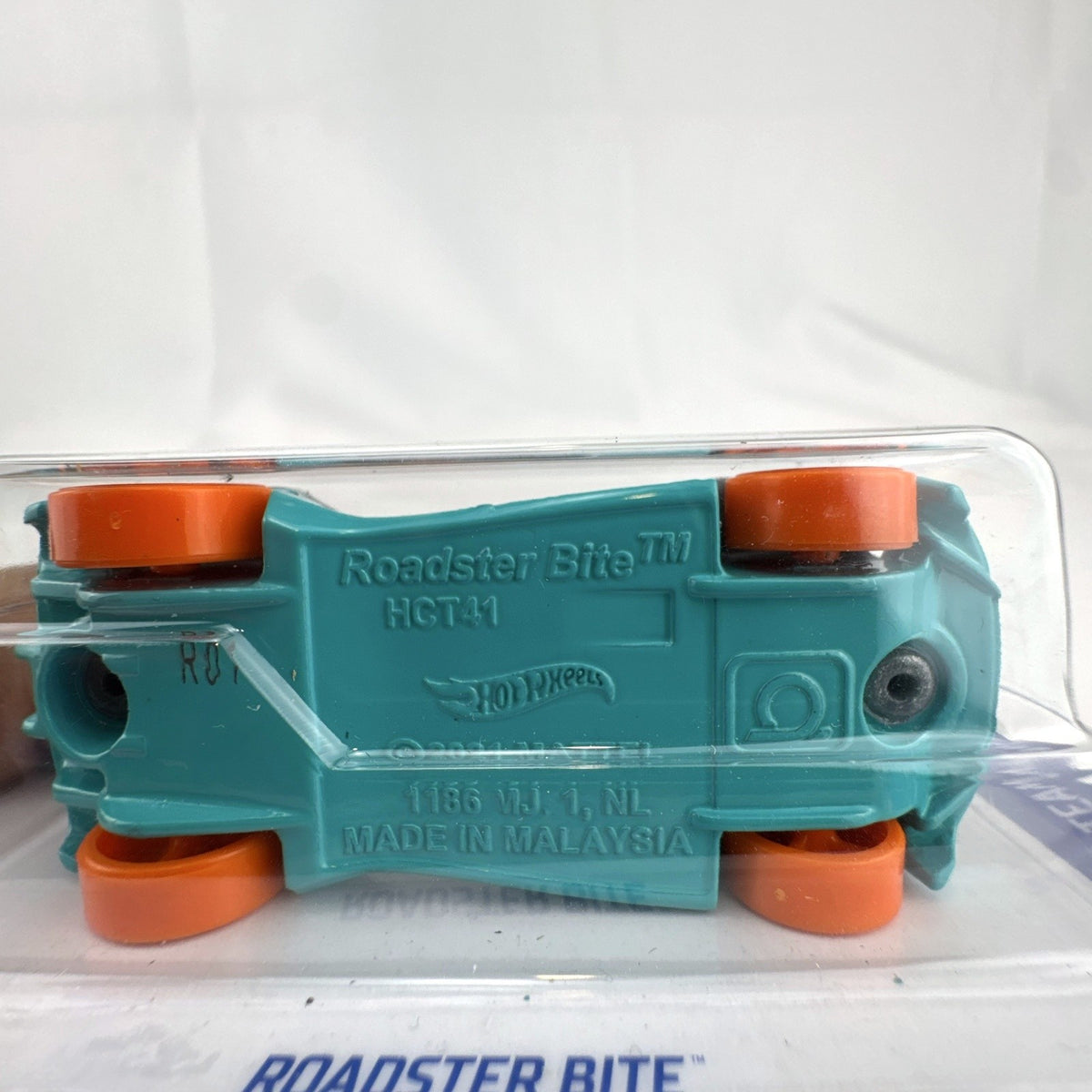 Hot Wheels Roadster Bite 1:64 scale diecast car sealed on card in satin gray with orange wheels.