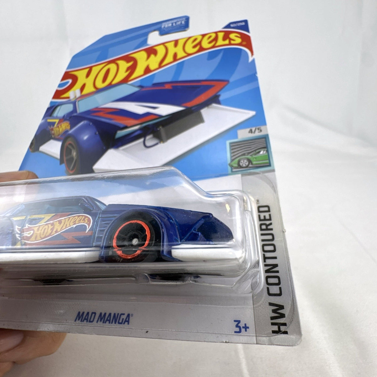 Hot Wheels Mad Manga 1:64 scale diecast car in dark blue, sealed on original HW Contoured blister card.