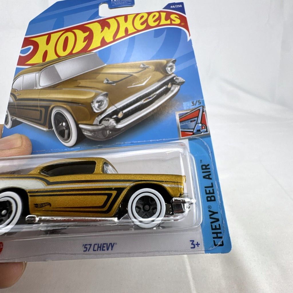 Hot Wheels 1957 Chevy Bel Air 1:64 scale diecast car in metallic gold with white wall tires sealed on card