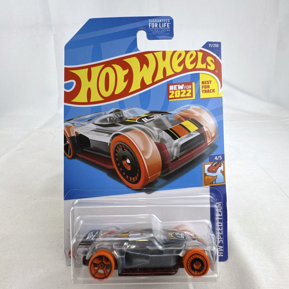 Hot Wheels Mach It Go 1:64 diecast car in factory sealed blister package with clear smoke body and orange track wheels.