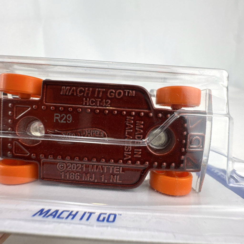 Hot Wheels Mach It Go 1:64 diecast car in factory sealed blister package with clear smoke body and orange track wheels.