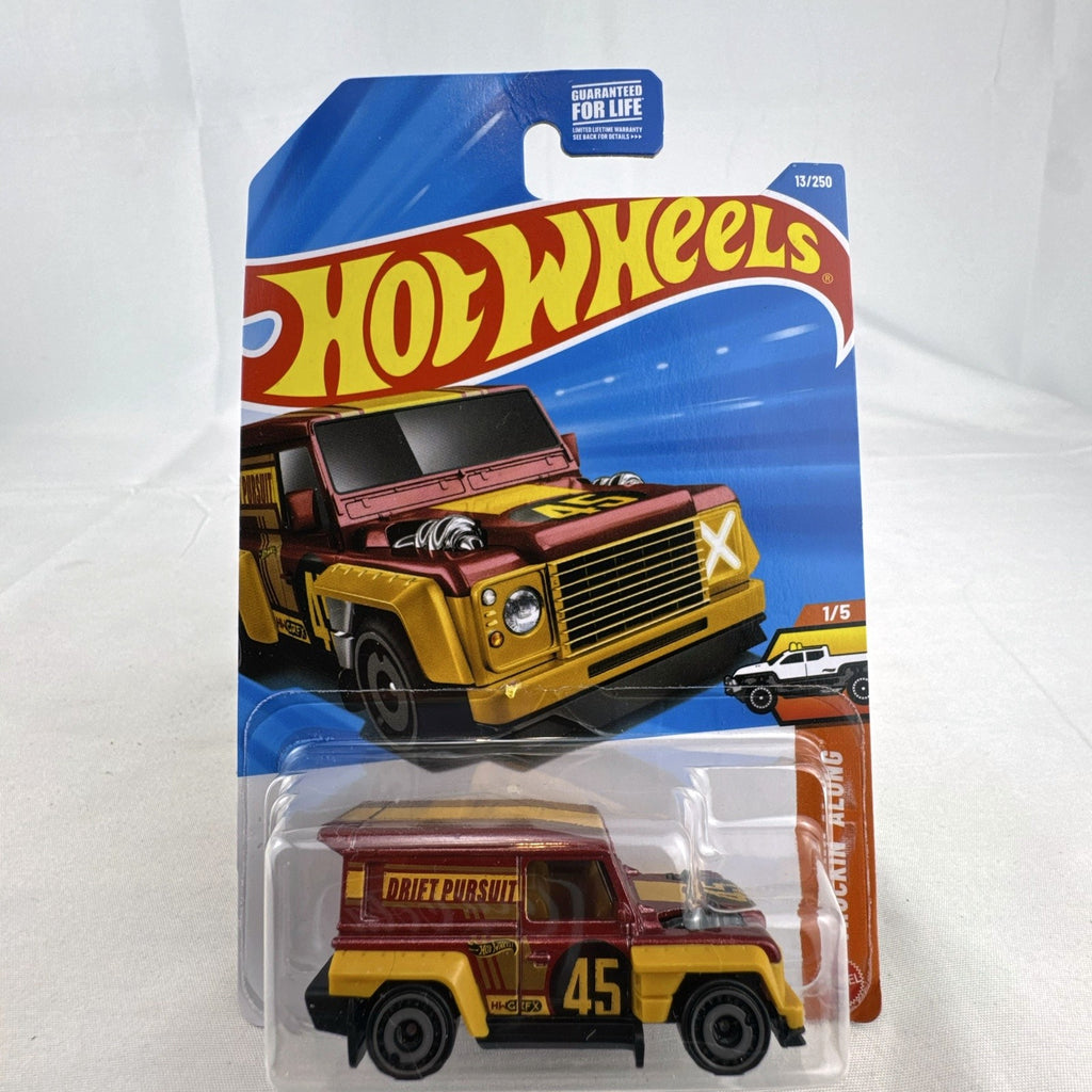 Hot Wheels 1:64 scale Drift-Ender Land Rover Defender diecast truck in dark red and gold, factory sealed on card.