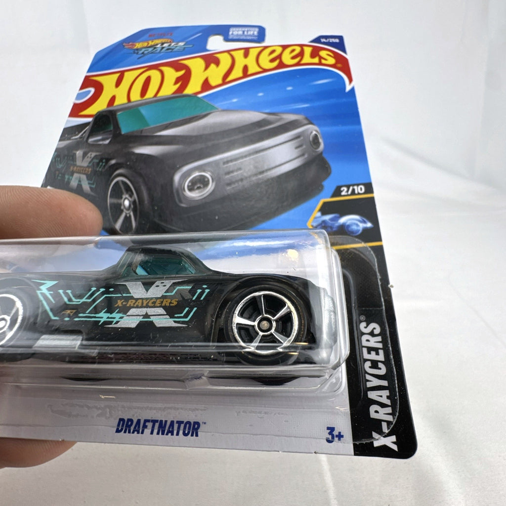 Hot Wheels Draftnator 1:64 scale black translucent diecast pickup truck in sealed X-Raycers packaging.